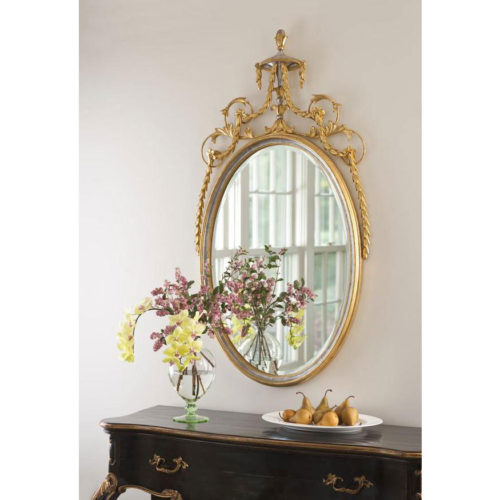 Adam style oval carved wood and wrought iron mirror with leaf drops and floral design. Mirror finished in antiqued gold leaf and silver leaf. Mirror has a beveled glass. This mirror is hand-crafted in Italy