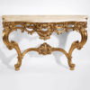 Louis XV style carved wood console with leaf scroll motif in antiqued gold leaf finish. Louis XV console has Calacotta gold marble top. This console table is hand made in Italy