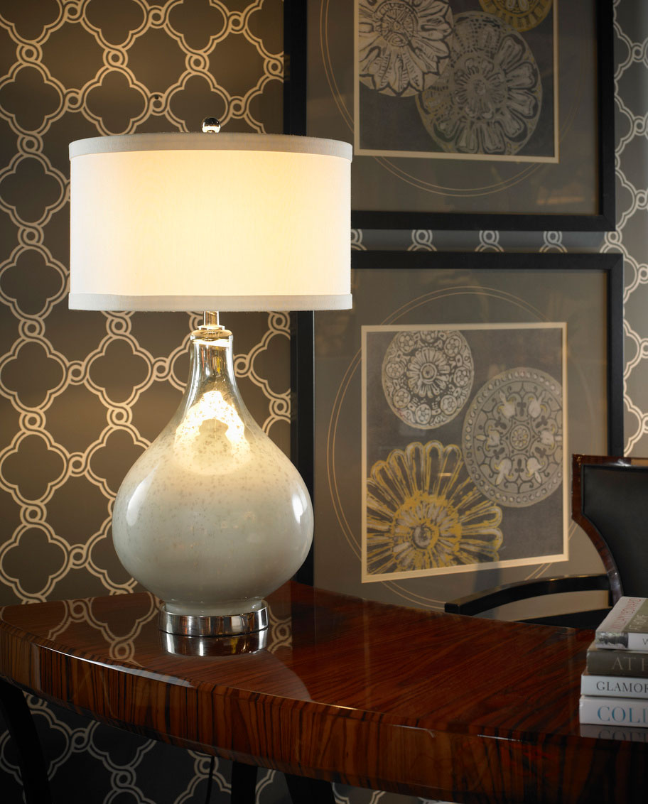 Interior setting with beautiful lamp. Its curved silhouette and milky-colored art glass created this elegant table lamp. Adorned with polished nickel accents and topped with an eggshell silk shade